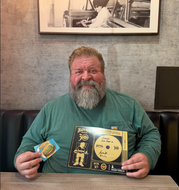 Andrew Edling holds his XXXL Triple King Challenge certificate and sticker at Fatburger on Tatum Boulevard in Cave Creek, Arizona.