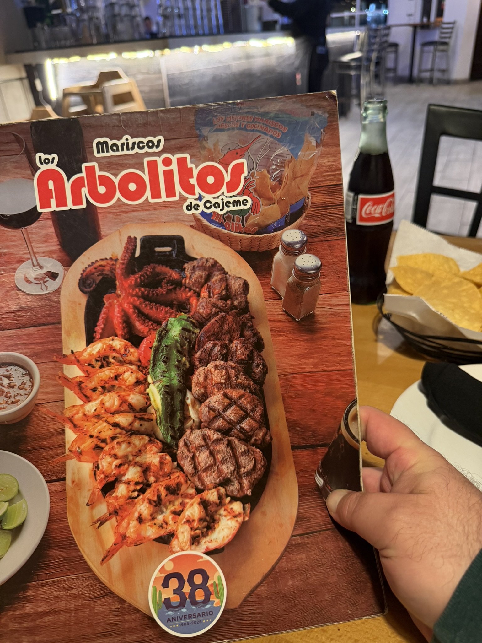 Los Arbolitos de Cajeme menu spread showing grilled seafood and meats on a wooden board
