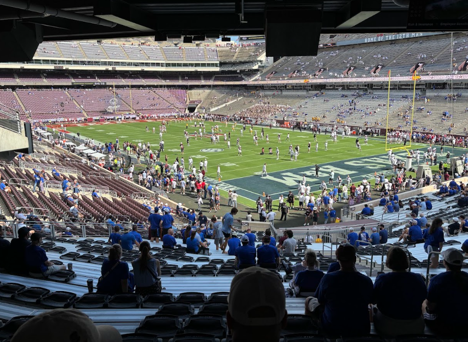 Players warm up at Kyle Field as fans take their seats before kickoff.